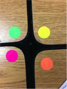 an image of some colorful dots on a wooden table with the text, use colored dots to make groups easy