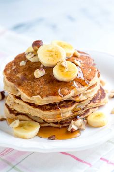 a stack of pancakes topped with bananas and syrup