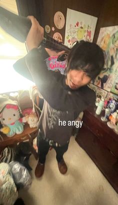 a woman standing in front of a bed holding a skateboard over her head with the words he angry written on it