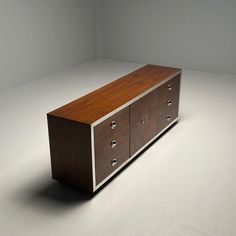 a large wooden cabinet sitting on top of a white floor in an empty room with no one around it