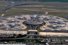 an aerial view of the airport with several planes parked at gates and parking spaces around it