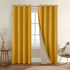 a living room with yellow curtains and a chair