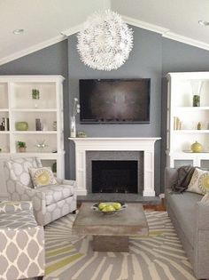 a living room filled with furniture and a flat screen tv mounted on the wall above a fireplace