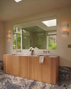 a bathroom with two sinks and mirrors in the middle of it's wall area