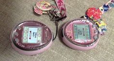 two pink electronic devices sitting next to each other on the floor with ribbons around them