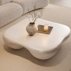 a white coffee table sitting on top of a carpeted floor next to a couch