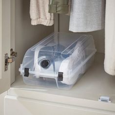 a plastic storage box sitting on top of a white shelf