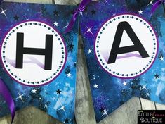 two paper banners with the letter h and stars on them, one has a purple ribbon