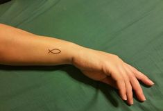 a person's arm with a small tattoo on the left side of their arm