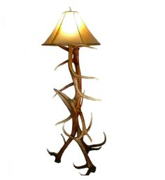 a lamp with antlers on it and a light shade hanging from the top of it