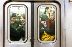 people are looking out the window of a subway car as it's doors open