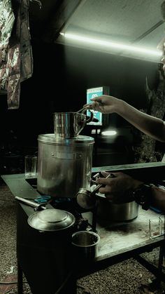 a man is cooking in the kitchen with pots and pans on the stove top