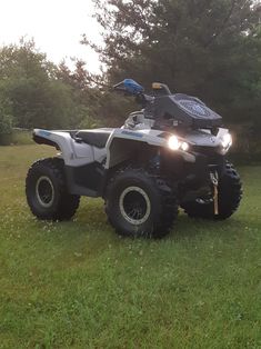 an atv is parked in the grass with its lights on and it's front wheel turned