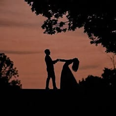 a man and woman standing next to each other in silhouette