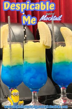 two glasses filled with blue, yellow and green liquid sitting on top of a table