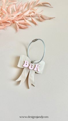 a pink and white bow with the letter b on it