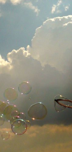 several soap bubbles floating in the air on a cloudy day