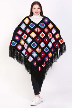 A crochet shawl for women that embodies boho charm and style, this lightweight sweater is a versatile and fashionable piece for any wardrobe. Handcrafted with intricate crochet work, it features a loose and flowy fit that drapes elegantly over the shoulders, creating a relaxed and effortless look. Perfect for layering over a simple top or dress, this boho poncho adds a touch of bohemian flair to any outfit. Whether styled with jeans for a casual day out or paired with a maxi skirt for a bohemian Black Bohemian Shawl For Fall, Black Bohemian Poncho Shawl, Bohemian Yarn Poncho For Fall, Bohemian Yarn Crochet Top, Bohemian Knit Poncho With Fringe, Bohemian Knitted Shawl For Beach, Bohemian Black Poncho For Fall, Spring Crochet Poncho Shawl, Bohemian Knitted Poncho For Fall