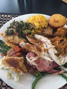 a white plate topped with meat and veggies on top of a woven place mat