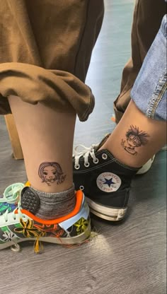 two people standing next to each other with tattoos on their legs