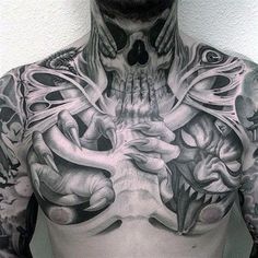 a man with lots of tattoos on his chest and hands holding something in front of him