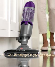 a woman is cleaning the floor with a vacuum