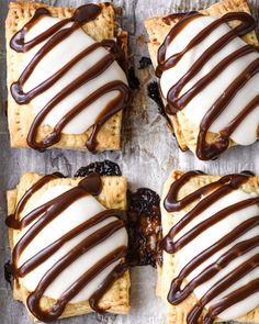 four square desserts with chocolate drizzled on them