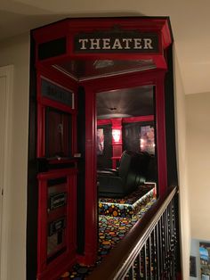 a red phone booth sitting next to a stair case