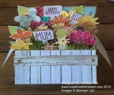 a close up of a greeting card with flowers in a wooden box on a table