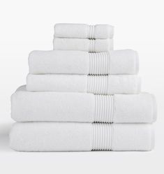 a stack of white towels stacked on top of each other in front of a white background