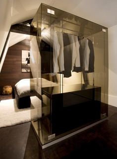 a closet with clothes hanging in it and a bed on the floor next to it