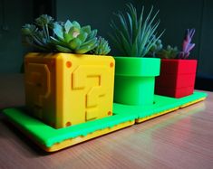 three plastic planters sitting on top of a wooden table