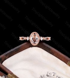 an engagement ring in a wooden box with white and pink diamonds on the band,