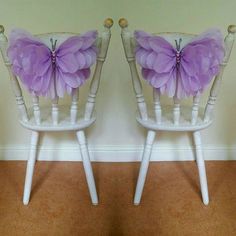 two white chairs with purple butterfly decorations on the back and sides, sitting side by side