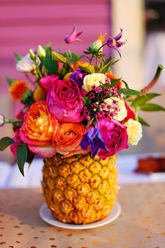 a pineapple vase filled with colorful flowers on top of a table next to the words, a ray of sunshine with a pineapple vase