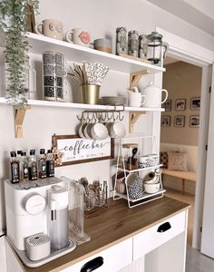 a kitchen counter with coffee cups and mugs on it, along with other items