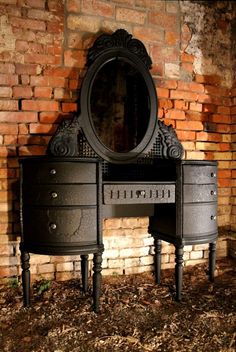 an old vanity with a mirror on it in front of a brick wall and floor