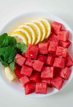 watermelon slices, lemons and mint on a white plate