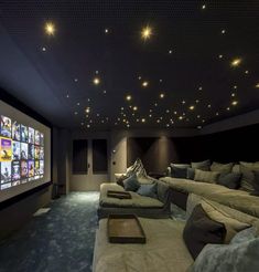 a home theater with two couches and a projector screen in the middle of the room