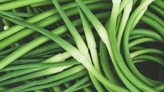 green beans are piled up together in this close - up photo, with the stems still attached