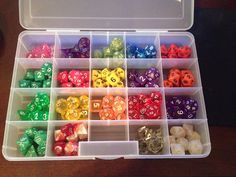 a plastic box filled with lots of different colored dice