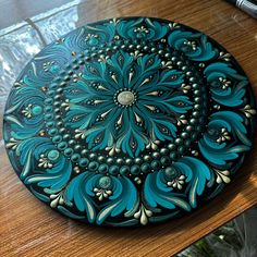 a blue and white plate sitting on top of a wooden table next to a pen