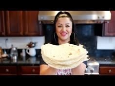 a woman is holding some tortillas in her hands