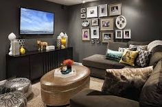 a living room with gray walls and pictures on the wall above the couch, coffee table and television