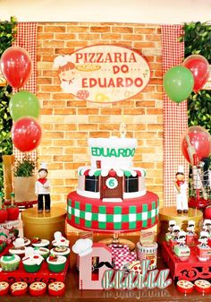 a table topped with lots of cakes and cupcakes next to a brick wall