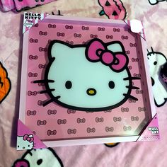 a hello kitty box sitting on top of a pink bed spread with hello kitty wallpaper