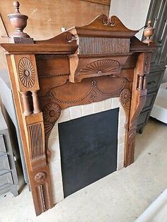 an old wooden fireplace with carvings on the mantle