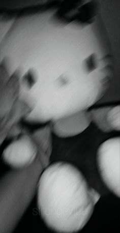 black and white photograph of teddy bear with blurry image in the foreground,