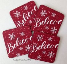 four red coasters with white snowflakes and the words believe, believe, believe