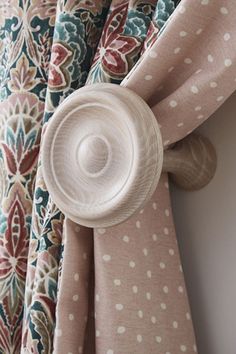 the curtain is hanging on the wall with polka dot print fabric and has a white button at the top